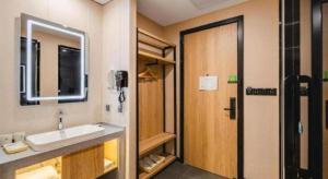 a bathroom with a sink and a wooden door at Green Tree Inn Shenyang Middle Street in Shenyang +73 photos