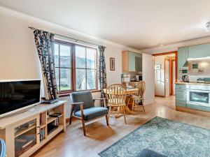 a living room with a television and a table with chairs at 1 Bed in Callander 45288 in Saint Fillans