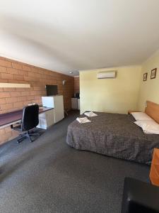a hotel room with a bed and a desk at The Lodge Village & Motel, Moranbah in Moranbah