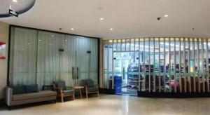 a lobby with chairs and a table and a glass wall at Green Tree Inn Luoyang Fenghuang Mansion Mudan Square Metro Station in Luoyang