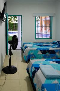 a room with three beds and a fan in it at Casa Hotel Villa Sabrosura in Mariquita +26 photos