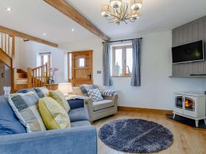 ein Wohnzimmer mit einem blauen Sofa und einem Fernseher in der Unterkunft 1 Bed in Cheltenham 60276 in Tirley