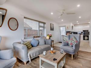 a living room with a couch and two chairs and a table at 2 Bed in Bacton 75391 in Bacton