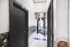 a hallway with a black door in a building at Super Hotel O Krishna Janam Bhoomi Formerly Ashirwad Palace in Mathura