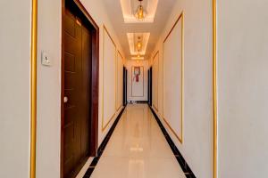 a hallway with black doors and a tile floor at HOTEL O R1 HOME STAY Jwalapur Railway Station in Bahādrābād