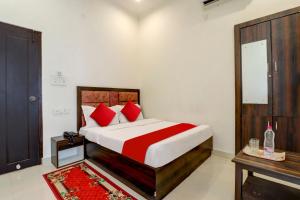 a bedroom with a large bed with red pillows at HOTEL O R1 HOME STAY Jwalapur Railway Station in Bahādrābād +17 photos