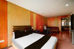 a bedroom with a bed in a room with wooden walls at Super Townhouse Narayanaguda Metro Station Formerly Hotel Anshu Grand in Vidya Nagar +24 photos