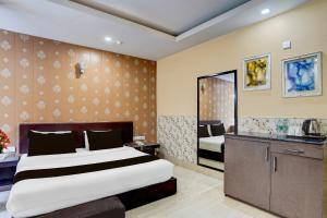a hotel room with a bed and a mirror at Super Townhouse Oak ONGC Crossway Formerly Hotel Gold Stone Comfort in Dehradun