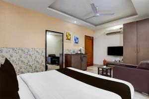 a bedroom with a bed and a living room at Super Townhouse Oak ONGC Crossway Formerly Hotel Gold Stone Comfort in Dehradun