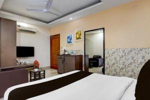 a bedroom with a bed and a living room at Super Townhouse Oak ONGC Crossway Formerly Hotel Gold Stone Comfort in Dehradun +21 photos