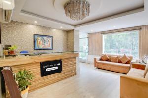 デヘラードゥーンにあるSuper Townhouse Oak ONGC Crossway Formerly Hotel Gold Stone Comfortのソファとシャンデリアのあるリビングルーム
