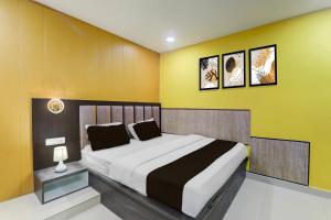 ゴーラクプルにあるSuper Hotel O Medical College Basaratpur Gorakhpurのベッドルーム1室(黄色い壁の大型ベッド1台付)
