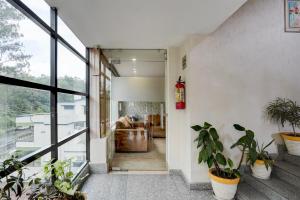 デヘラードゥーンにあるSuper Townhouse Oak ONGC Crossway Formerly Hotel Gold Stone Comfortの鉢植えの廊下 +22枚の写真