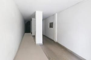 an empty hallway with white walls and a white wall at Super Townhouse Bank More Dhanbad Formerly Rise And Dine in Dhanbād +21 photos