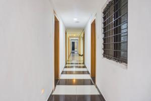 a hallway with black and white tiled floors and walls at Super Collection O Manjari - Mundhwa Road Formerly 7 Treats in Mundhwa