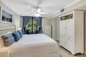 a bedroom with a white bed and a ceiling fan at SW122D: 122D Shipwatch in Isle of Palms +23 photos