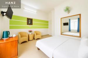 a bedroom with a bed and a mirror and chairs at S79 Bao Khoi Hotel in Vung Tau +5 photos