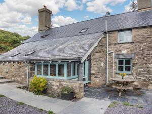 a stone cottage with a picnic table in front of it at 4 Bed in Betws y coed 52111 in Capel Garmon