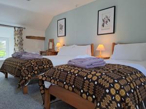 two beds in a hotel room with purple blankets at 4 Bed in Betws y coed 52111 in Capel Garmon
