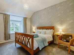 una camera da letto con un letto grande e una sedia di 4 Bed in Betws y coed 52111 a Capel Garmon
