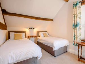 ハーティントンにある4 Bed in Hartington 88196の白い壁の屋根裏部屋のベッドルームにベッド2台