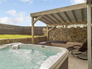 a hot tub in a patio with a pergola at 5 Bed in Botwnnog 55385 in Bottwnog