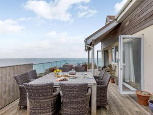 a table and chairs on a balcony with the ocean at 4 Bed in West Bay 86538 in Bridport