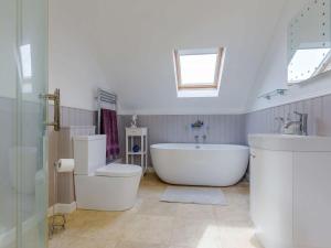 a bathroom with a tub and a toilet and a sink at 4 Bed in West Bay 86538 in Bridport +64 photos
