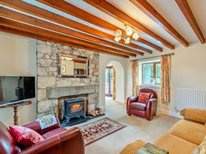 Whitfordにある3 Bed in Holywell 89614の石造りの暖炉と革製家具付きのリビングルーム