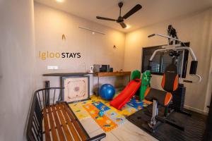 a room with a gym with a treadmill and a simulator at Igloo Stays Kakkanad in Kakkanad