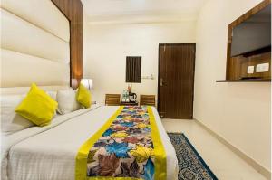 a bedroom with a bed with a colorful blanket on it at Hotel Luck Recdancy mahipalpur in New Delhi