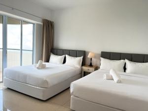 a hotel room with two beds and a window at Cloud Forest Homestay Genting Highlands in Genting Highlands