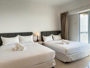Dos camas una al lado de la otra en un dormitorio. en Cloud Forest Homestay Genting Highlands, en Genting Highlands