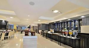 a restaurant with a bar with a lot of drinks at Travello Hotel Bandung in Bandung