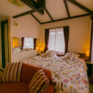 Un dormitorio con una cama grande y un sofá. en 箱根エレガンス, en Hakone 43 fotos más