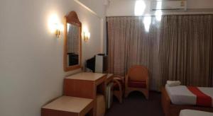 a small hotel room with a bed and a desk at Pailyn Hotel in Sukhothai