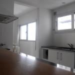 an empty room with a counter and two windows at Apartamentos 44 in La Plata