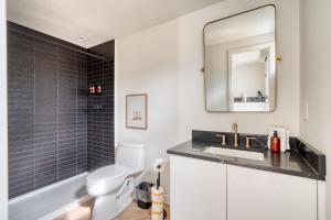 a bathroom with a sink and a toilet and a mirror at Stay Portland - Alberta Arts District Studio Suite in Portland