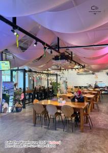 a restaurant with tables and chairs under a purple ceiling at The Cozytainer in Taiping