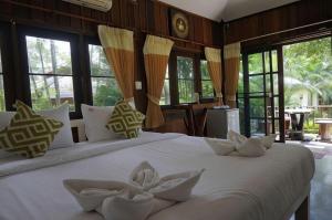a bedroom with a large white bed with windows at De Bua Valley in Ban Kom +112 photos
