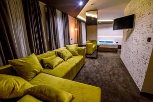 萊斯科瓦茨的住宿－Hotel Bavka，一间带黄色沙发的客厅和一间卧室