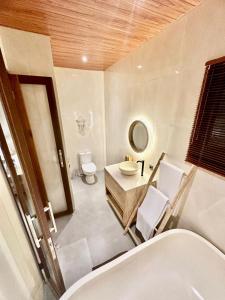a bathroom with a sink and a toilet and a mirror at wiku villa in Blahbatu +6 photos