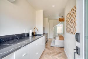 a kitchen with white cabinets and black counter tops at Stay Portland - Alberta Arts-tastic Mother-In-Law Suite in Portland
