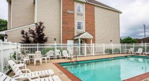 a swimming pool in front of a house with white fences at Quality Inn & Suites in Belinda City +54 photos
