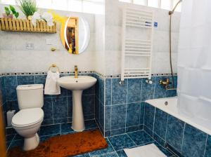 a blue tiled bathroom with a toilet and a sink at Ala s Old District Apartment in Kutaisi +27 photos