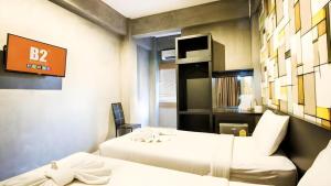 a room with two beds and a sign on the wall at B2 Lanna Boutique & Budget Hotel in Chiang Mai