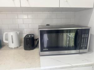 un forno a microonde seduto su un bancone in cucina di Cozy home a Calgary