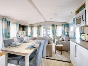 ニュー・ミルトンにある2 Bed in New Milton 89709のテーブルと椅子のあるキッチンとリビングルーム