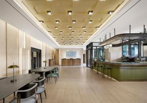 a lobby with tables and chairs and a bar at Pullman Ambassador Seoul Eastpole in Seoul