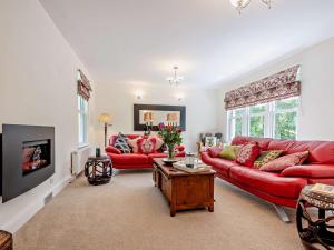 Langholmにある3 Bed in Langholm 95053のリビングルーム(赤いソファ、テーブル付)